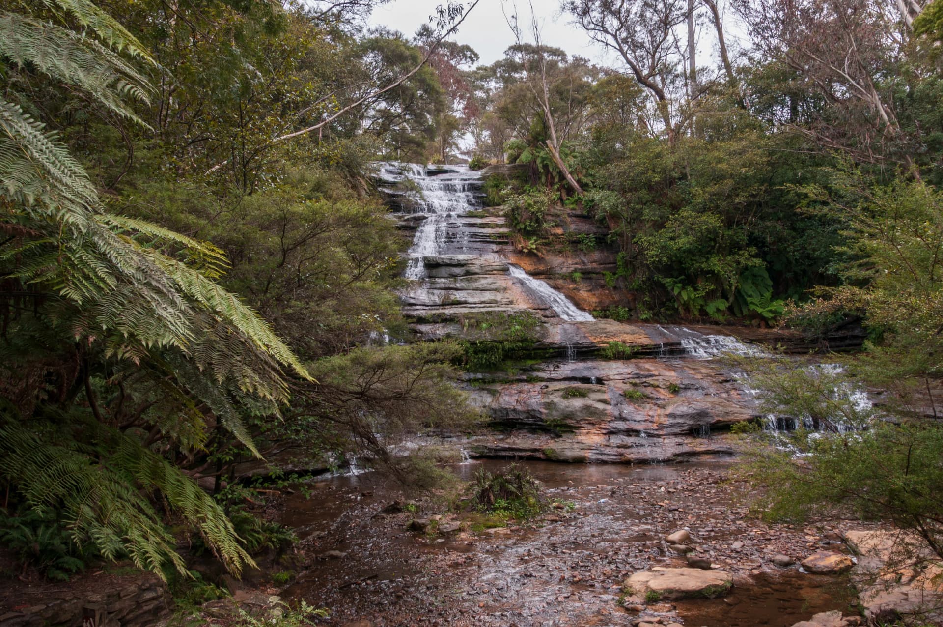 Waterfall over layered sandstone