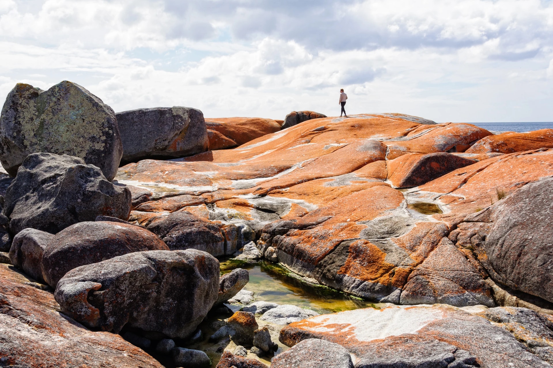 Walker on lichen boulders, Bay of Fires